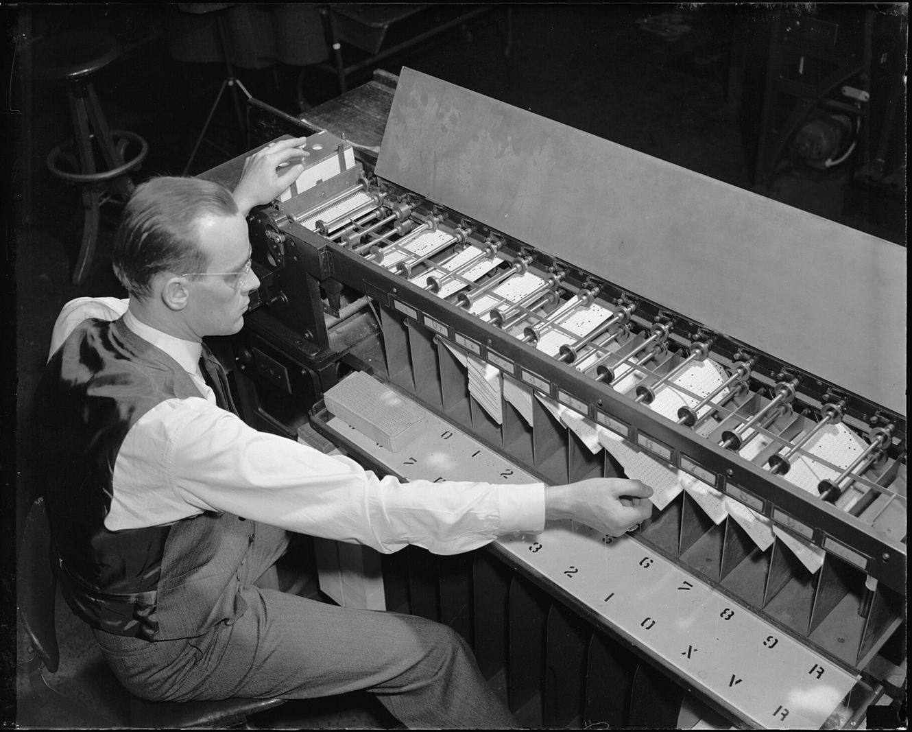 An operator sorts punched cards on a tabulating machine, 1940
